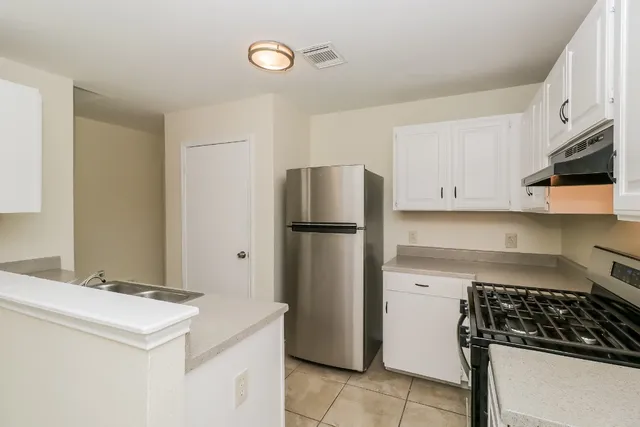 a kitchen with a refrigerator and a stove top oven