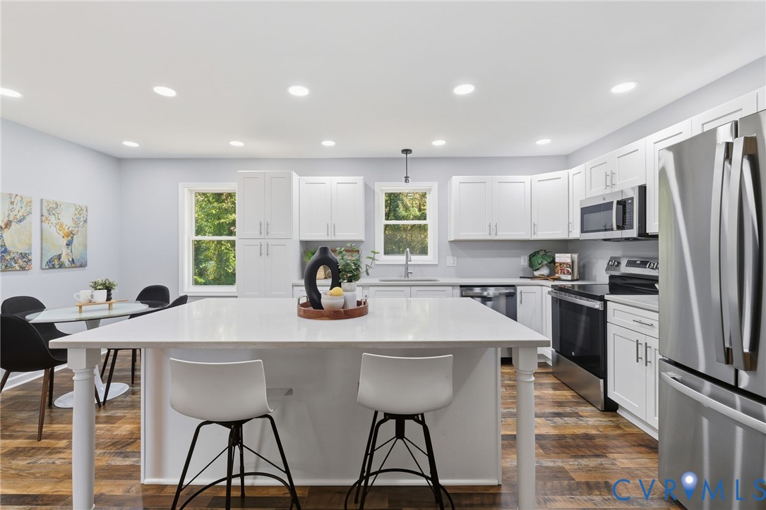 310 Stratton Street Crewe, VA 23930 - Photo 2 of 25 a kitchen with stainless steel appliances kitchen island granite countertop a table chairs microwave and refrigerator