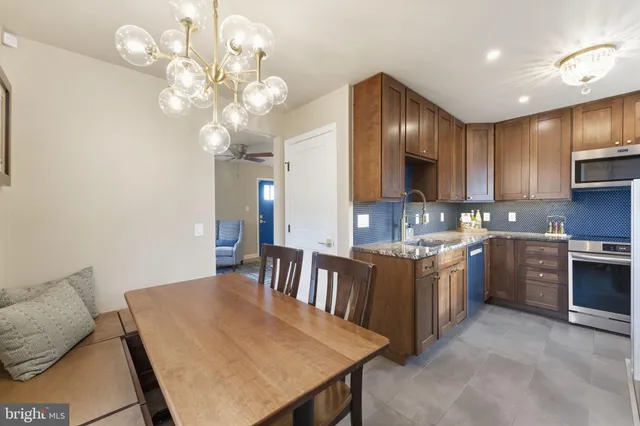 a kitchen with granite countertop stainless steel appliances a sink stove and cabinets