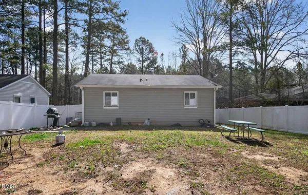a view of a house with backyard and trees