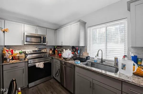 a kitchen with sink a microwave and cabinets