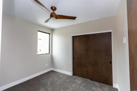 an empty room with windows and fan