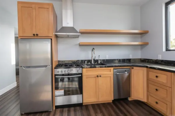 a kitchen with stainless steel appliances granite countertop a refrigerator and a stove top oven