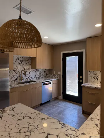 a kitchen with stainless steel appliances granite countertop a stove a sink and a refrigerator