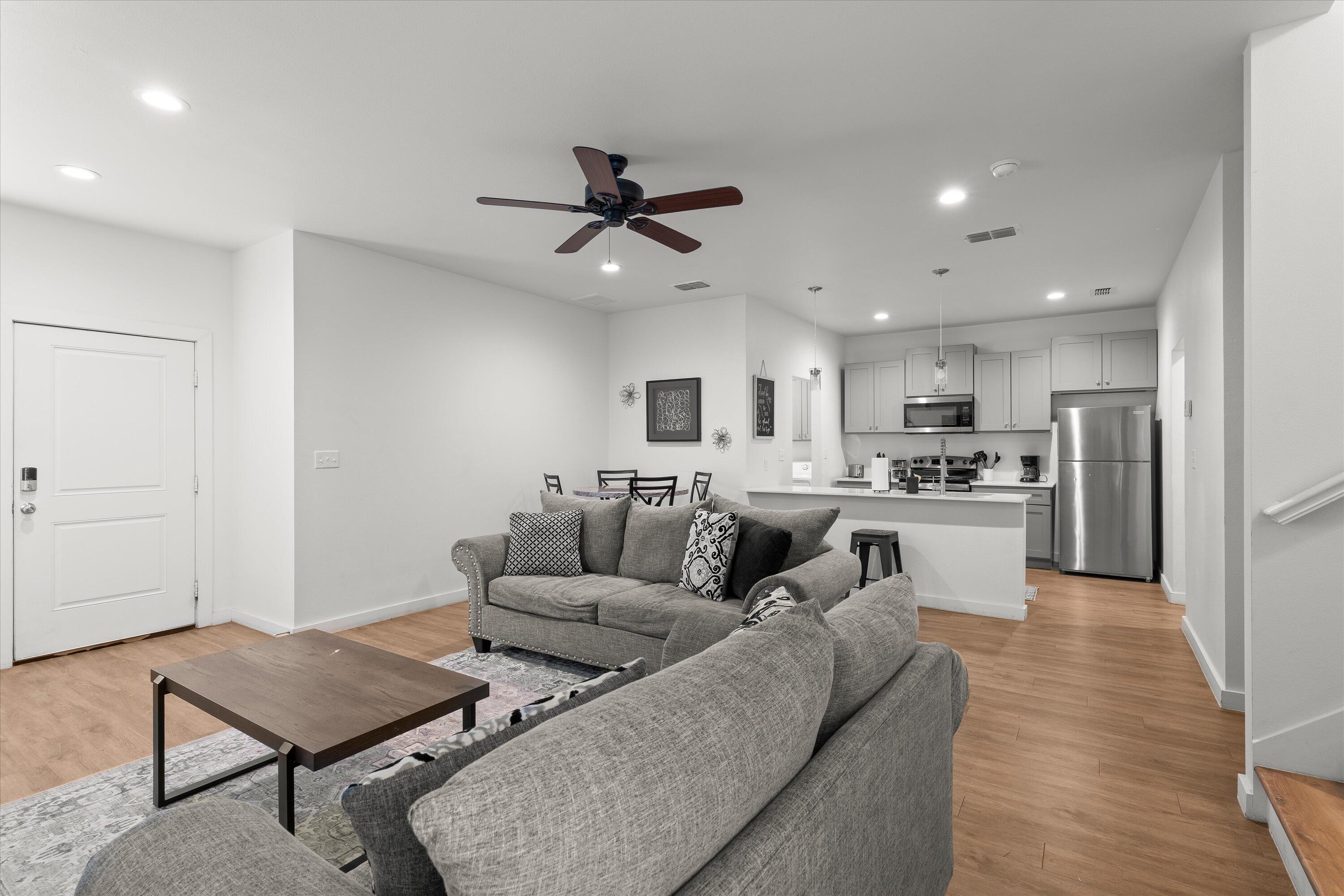 5736 Lehigh Street Lubbock, TX 79416 - Photo 4 of 23 a living room with couches and kitchen view with wooden floor