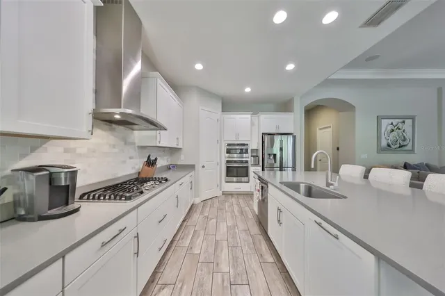 a living room with furniture a flat screen tv and a ceiling fan