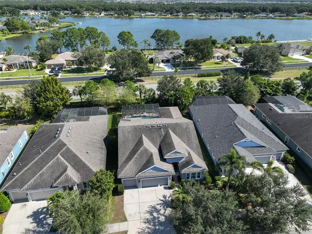 a view of a white house with a swimming pool and a yard