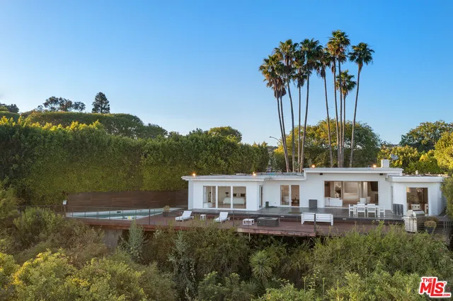 a front view of a house with balcony and garden