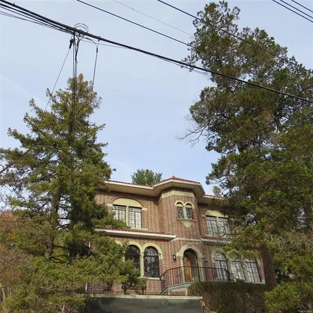 a front view of a house with a tree