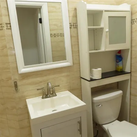 a bathroom with a toilet sink and mirror