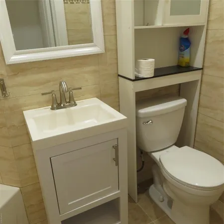 a bathroom with a toilet sink and mirror