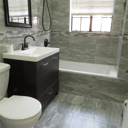 a bathroom with a sink mirror and a bathtub