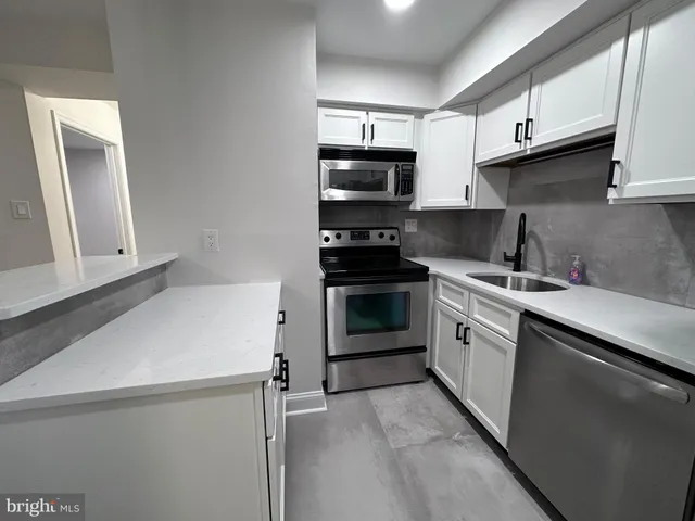 a kitchen with stainless steel appliances granite countertop a sink stove and microwave