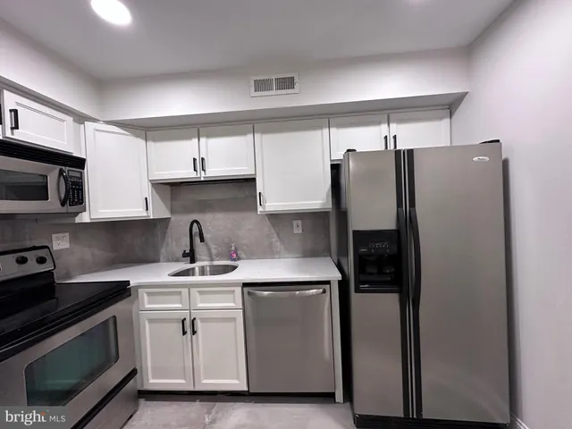 a kitchen with stainless steel appliances a refrigerator sink and microwave