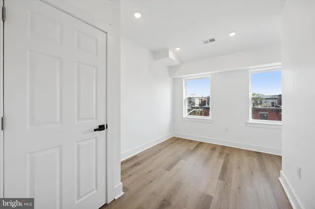 a view of an empty room with wooden floor