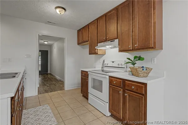 a kitchen with stainless steel appliances granite countertop a sink a stove and cabinets