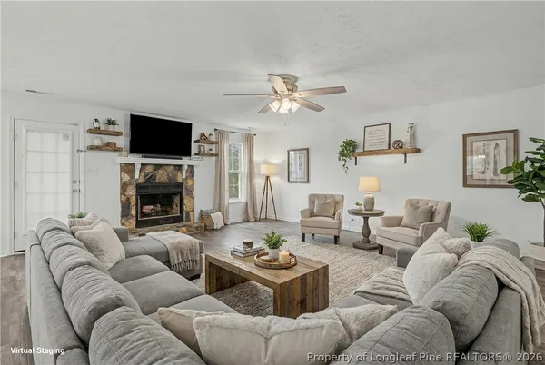 a living room with furniture a fireplace and a flat screen tv