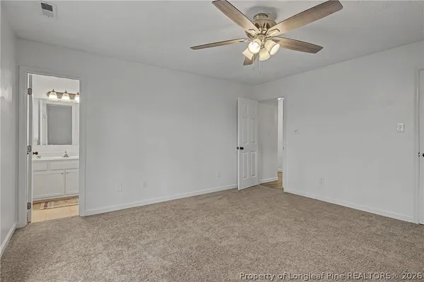 a view of an empty room and a chandelier fan