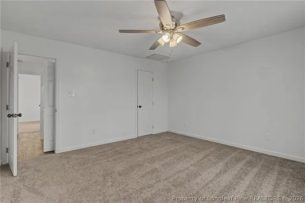a view of an empty room with a chandelier fan