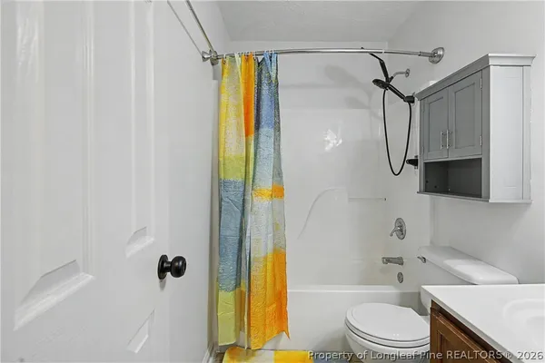 a bathroom with a bathtub shower sink vanity and toilet