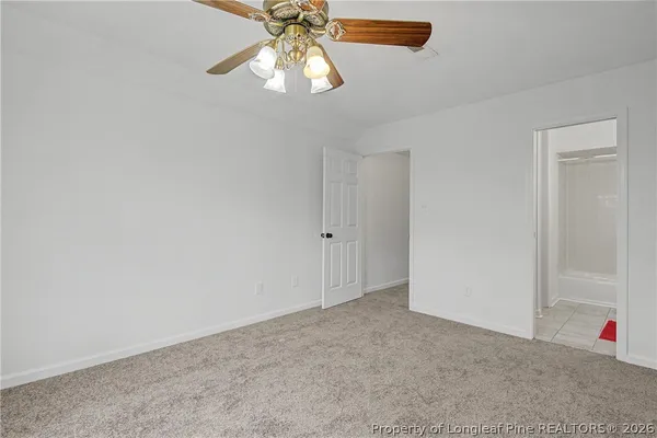 an empty room with closet and a chandelier fan