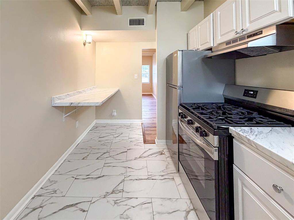 219 Northwest 3rd Avenue, Unit B Gainesville, FL 32601 - Photo 11 of 20 a kitchen with stainless steel appliances a stove a refrigerator and cabinets