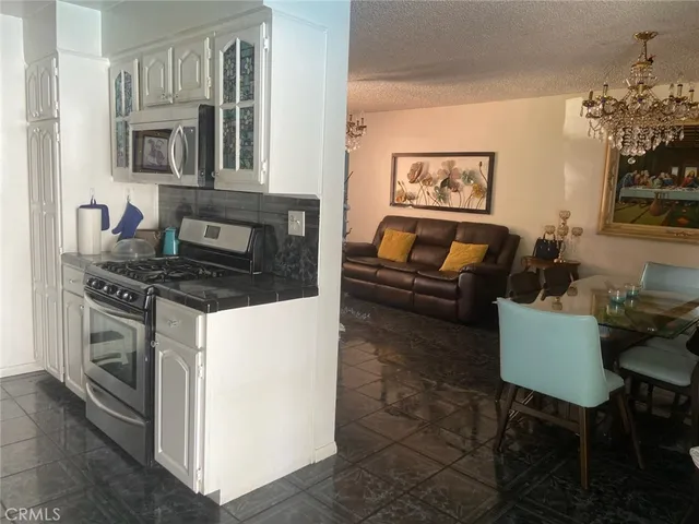 a kitchen with stainless steel appliances a stove a sink cabinets and a dining table