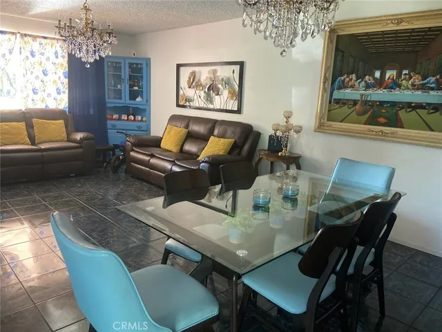 a view of a dining room with furniture a chandelier and window