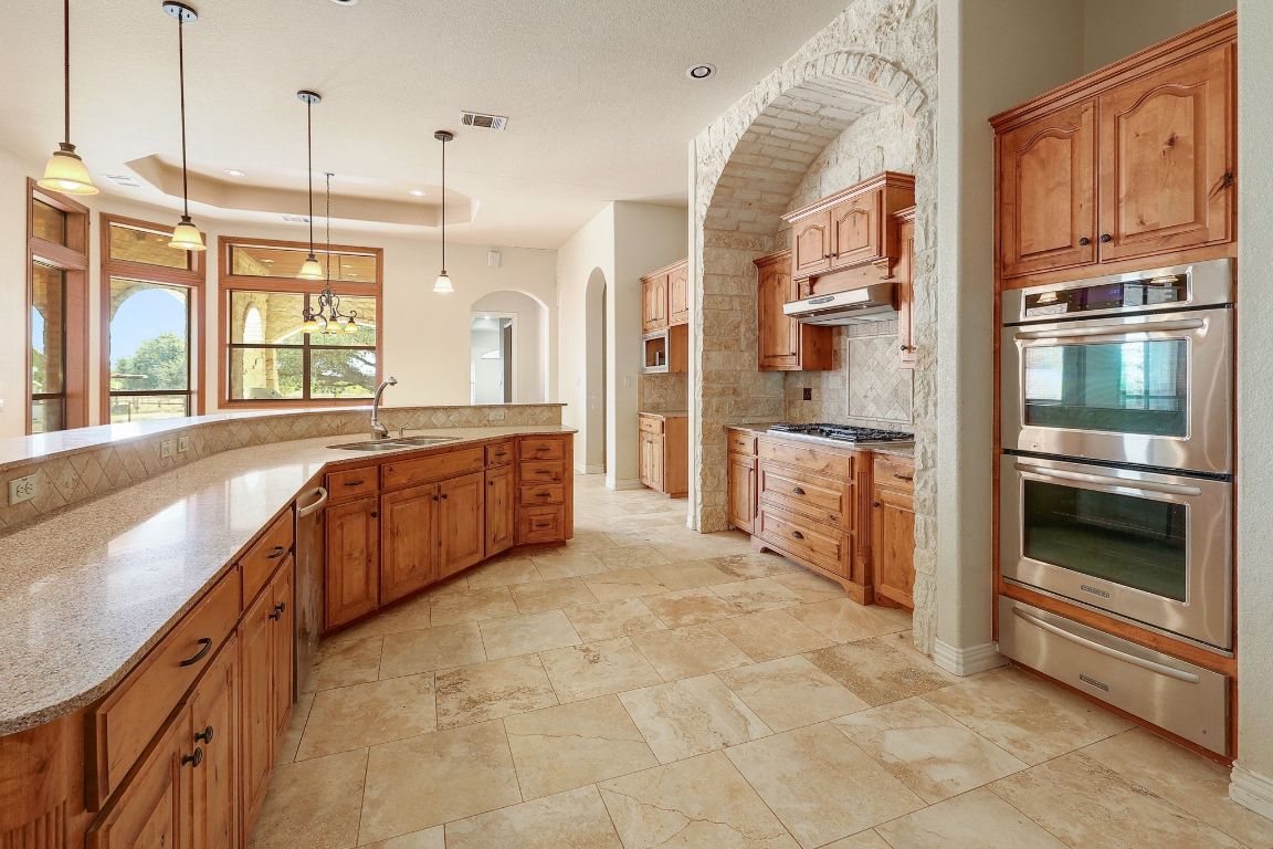 22300 Farm To Market Road 971 Granger, TX 76530 - Photo 13 of 37 a large kitchen with stainless steel appliances granite countertop a stove and a sink