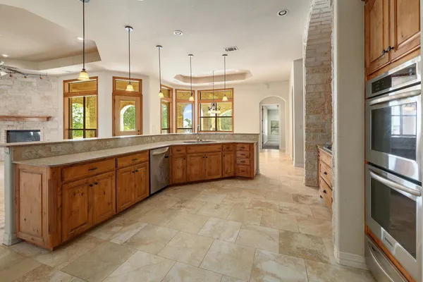 a large kitchen with granite countertop a stove a sink and dishwasher