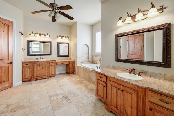 a spacious bathroom with a double vanity sink a mirror and a bathtub