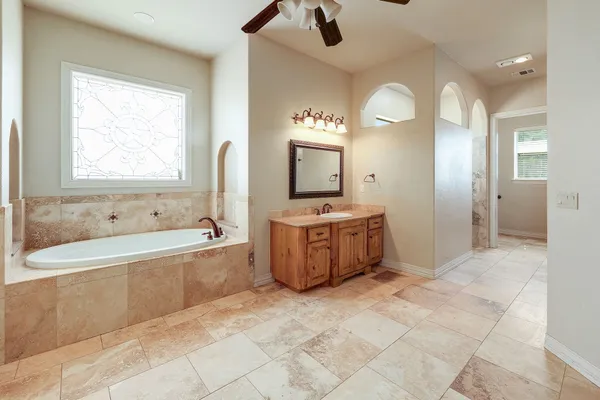 a bathroom with a tub sink and mirror