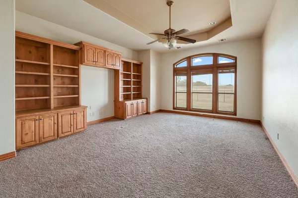 a view of an empty room with a window and chandelier