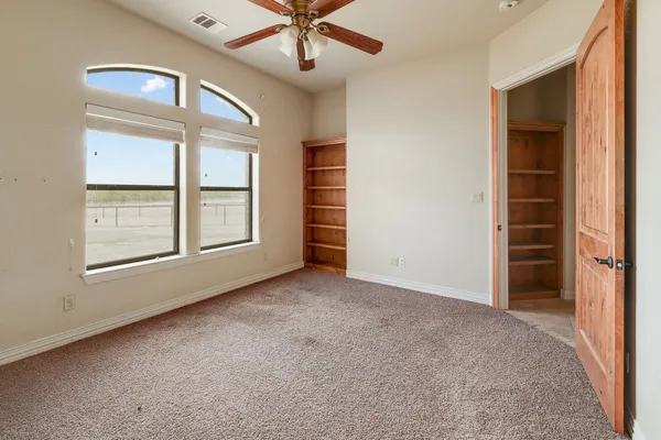 an empty room with closet and windows