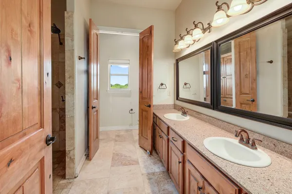 a spacious bathroom with a double vanity sink and a mirror