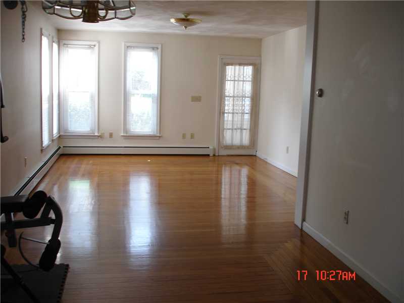 44 Pine Street Woonsocket, RI 02895 - Photo 5 of 10 Living Room. View of living room from dining area. Beautiful hardwoods. Door leads to closed in front porch.