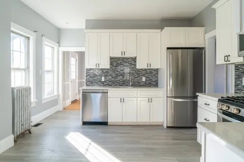 a kitchen with stainless steel appliances granite countertop a refrigerator sink and stove