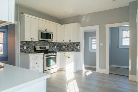 a kitchen with stainless steel appliances granite countertop a stove top oven a sink and a refrigerator