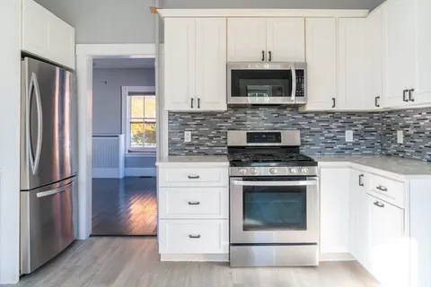 a kitchen with granite countertop a stove and a refrigerator