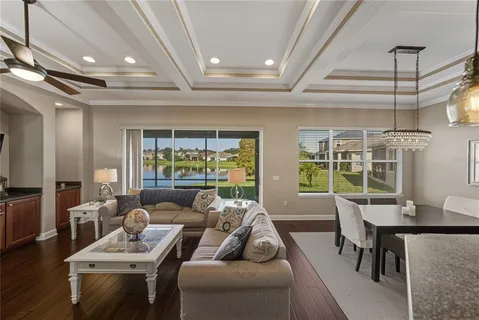 a dining room with furniture a kitchen and chandelier