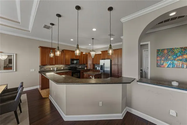 a kitchen with stainless steel appliances granite countertop a sink stove and refrigerator