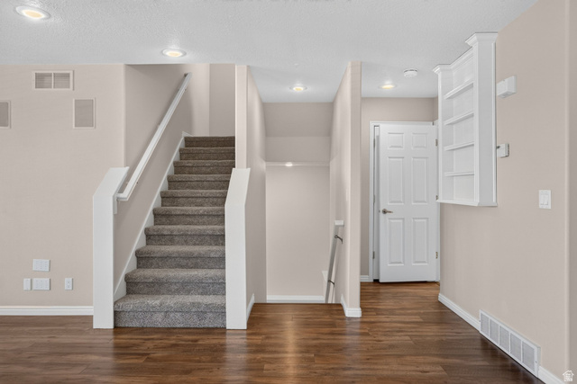 1305 Alpine Way Provo, UT 84606 - Photo 13 of 56 Wood-finish flooring, recessed lighting, carpeted staircase with white railing, built-in shelving, and a six-panel door