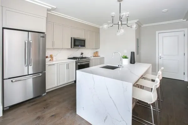 a kitchen with kitchen island a counter appliances a sink and cabinets