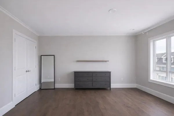 an empty room with windows and cabinet