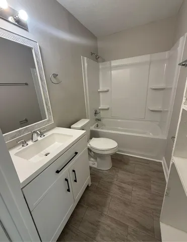 a bathroom with a double vanity sink toilet mirror and bathtub