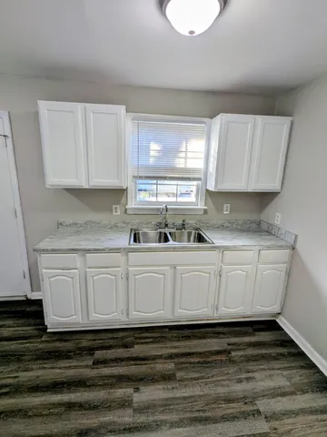 a white kitchen with granite countertop white cabinets and a granite counter tops