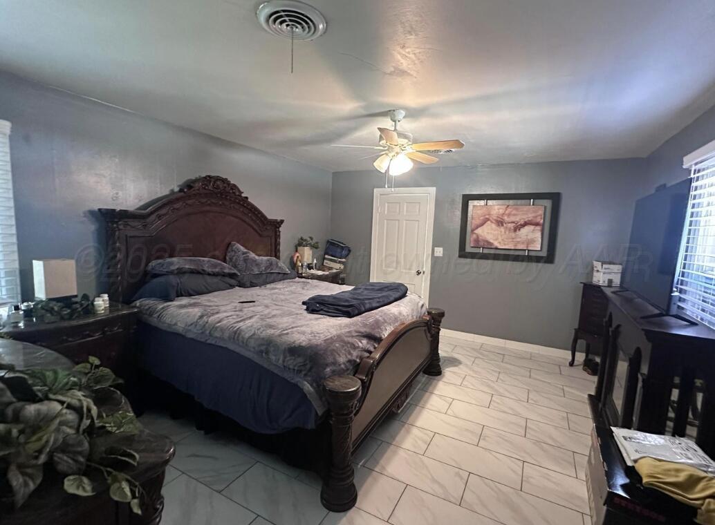 310 Ave L Sunray, TX 79086 - Photo 12 of 24 a bedroom with a bed and a chandelier