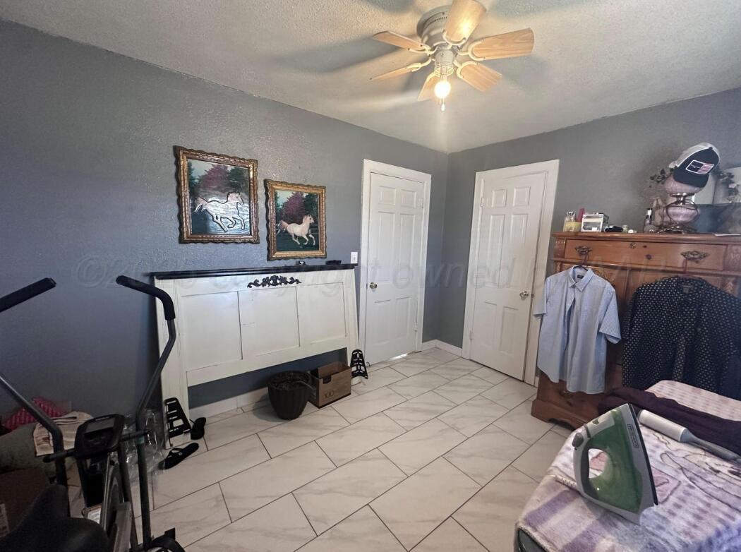 310 Ave L Sunray, TX 79086 - Photo 20 of 24 a bedroom with a bed and a chandelier