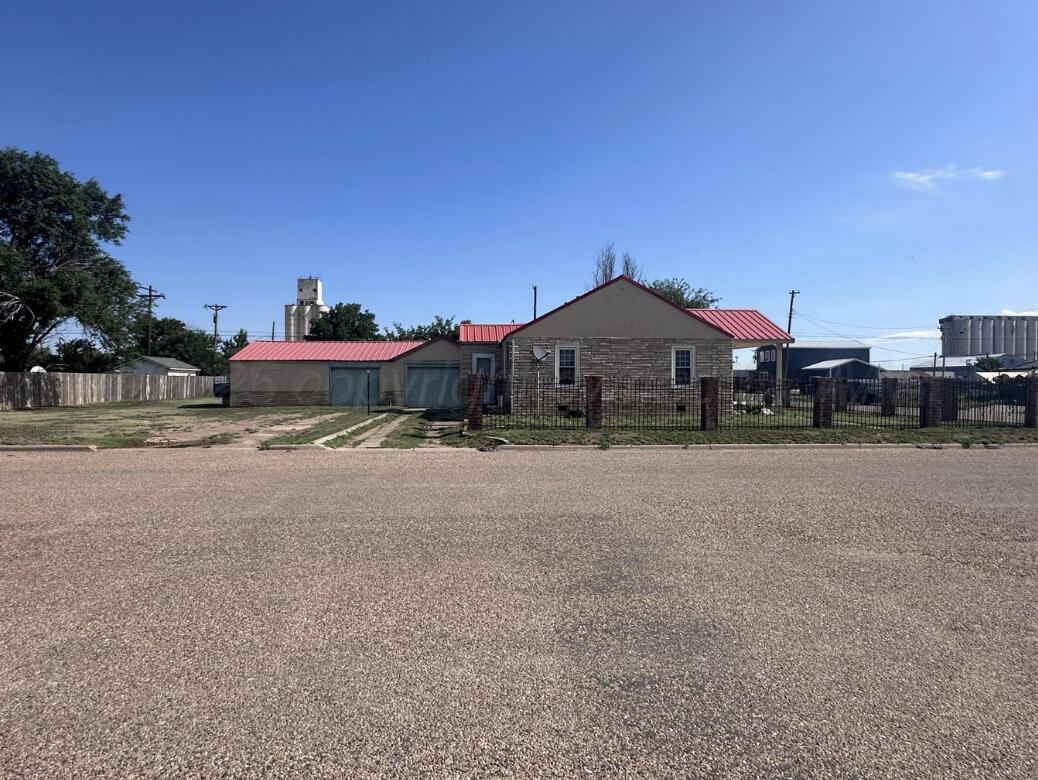 310 Ave L Sunray, TX 79086 - Photo 4 of 24 a front view of a house with a yard and a car parked