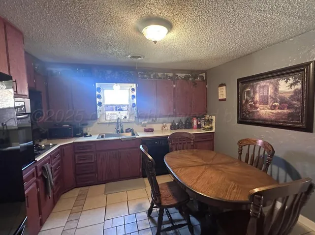 a kitchen with a table chairs sink and cabinets